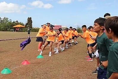 グラウンドで綱引きをする子どもたち
