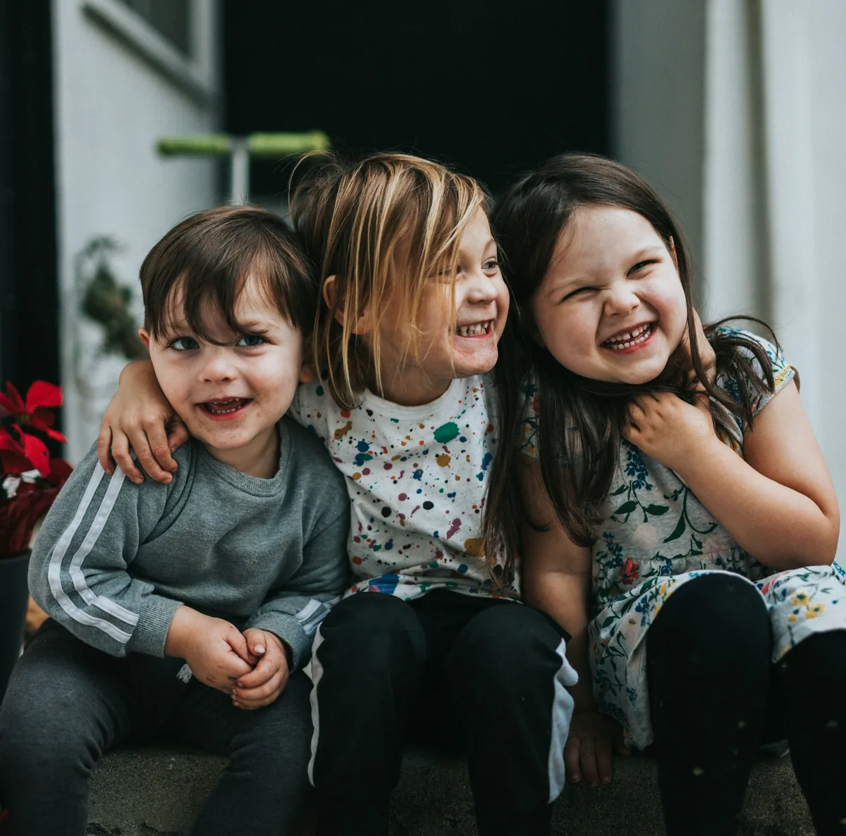 肩を組んで笑う3人の子ども