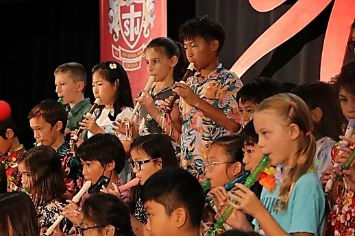 ステージでリコーダーを演奏する生徒たち